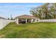 View of a spacious backyard with a white fence, providing privacy, and a covered area for outdoor activities and storage at 8330 Se 161St St, Summerfield, FL 34491