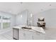 Well-lit kitchen showcasing a marble countertop island with stainless steel sink and faucet fixtures at 8330 Se 161St St, Summerfield, FL 34491
