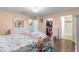 Bedroom showcases wood floors, floral bedding, walk-in closet, and en-suite bathroom at 8710 Sw 91St Pl # E, Ocala, FL 34481