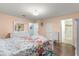 Bedroom showcasing wood floors, floral bedding, and access to a bathroom at 8710 Sw 91St Pl # E, Ocala, FL 34481