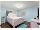 Cozy bedroom features a white bed frame, wood floors, and natural light at 8710 Sw 91St Pl # E, Ocala, FL 34481