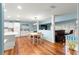 Dining area with hardwood floors, white table, and open view to kitchen and living spaces at 8710 Sw 91St Pl # E, Ocala, FL 34481
