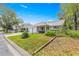 Charming single-story home with an attached garage, turquoise shutters and manicured landscaping at 8710 Sw 91St Pl # E, Ocala, FL 34481