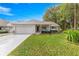 Inviting single-story home featuring an attached garage, colorful turquoise shutters, and a well-maintained lawn at 8710 Sw 91St Pl # E, Ocala, FL 34481