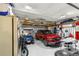 Well-organized garage featuring epoxy floors, a red car, a golf cart, and ample storage at 8710 Sw 91St Pl # E, Ocala, FL 34481
