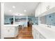Bright kitchen features white cabinets, an island, and wood flooring with an open view to the dining area at 8710 Sw 91St Pl # E, Ocala, FL 34481