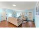 Bright living room features hardwood floors, light blue walls and comfortable seating with natural light at 8710 Sw 91St Pl # E, Ocala, FL 34481