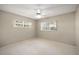 This bedroom features neutral paint, carpet flooring, ceiling fan, and double-paned windows at 9025 Sw 94Th Ln # C, Ocala, FL 34481