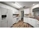 Bright kitchen with white cabinets, stainless appliances, and granite countertops with wood floors at 9025 Sw 94Th Ln # C, Ocala, FL 34481