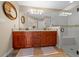 Bright bathroom featuring dual sinks, wood cabinetry, granite countertops, and a glass enclosed walk-in shower at 9436 Se 163Rd St, Summerfield, FL 34491