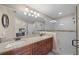 Bathroom featuring dual sinks, granite countertops, and a glass enclosed shower at 9436 Se 163Rd St, Summerfield, FL 34491