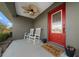 Inviting front porch features rocking chairs, ceiling fan, and a bright red front door at 9436 Se 163Rd St, Summerfield, FL 34491