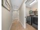 Hallway view to laundry room featuring modern washer and dryer with shelving and storage space at 9436 Se 163Rd St, Summerfield, FL 34491