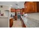 Well-equipped kitchen featuring granite counters, stainless appliances, tile flooring, and custom wood cabinets at 9436 Se 163Rd St, Summerfield, FL 34491