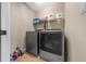 Functional laundry room with a modern washer, dryer, shelving, and storage solutions at 9436 Se 163Rd St, Summerfield, FL 34491