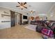 Spacious living room featuring decorative sliding barn doors and a comfortable leather sectional sofa at 9436 Se 163Rd St, Summerfield, FL 34491