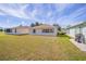 Large backyard featuring lush green grass, a grill and a view of the home's exterior and surrounding landscaping at 9575 Sw 92Nd Street Rd, Ocala, FL 34481
