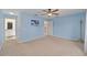 Simple bedroom with blue walls, carpeted floor and views to ensuite bathroom and hallway at 9575 Sw 92Nd Street Rd, Ocala, FL 34481