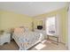 Cozy bedroom featuring a patterned bedspread, a nightstand, and a window with natural light at 9575 Sw 92Nd Street Rd, Ocala, FL 34481