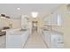 Bright kitchen with white cabinets, tile floors, and pass-through to the living area, ideal for easy meal prep at 9575 Sw 92Nd Street Rd, Ocala, FL 34481