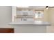 Bright kitchen showcasing white cabinets, tile floors, and breakfast bar overlooking the dining area at 9575 Sw 92Nd Street Rd, Ocala, FL 34481