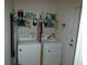 Functional laundry room with washer, dryer, and plenty of shelving for storage at 9610 Sw 198Th Cir, Dunnellon, FL 34432