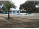 Beautiful community pool with blue building in the background, surrounded by nature at 9610 Sw 198Th Cir, Dunnellon, FL 34432