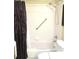 Clean bathroom with tub and shower featuring a shower curtain and grab bar for safety at 11792 Sw 137Th Loop, Dunnellon, FL 34432