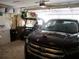 A garage that contains a car, a golf cart, a laundry machine, and storage shelves at 11792 Sw 137Th Loop, Dunnellon, FL 34432