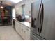 Modern kitchen featuring white cabinets, stainless steel appliances and adjacent dining area at 11792 Sw 137Th Loop, Dunnellon, FL 34432