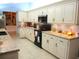 Spacious kitchen featuring white cabinets, black appliances, granite countertops, and ample storage at 11792 Sw 137Th Loop, Dunnellon, FL 34432