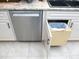 Modern kitchen featuring stainless steel dishwasher, built-in trash receptacle and white cabinets at 11792 Sw 137Th Loop, Dunnellon, FL 34432