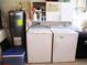 Functional laundry area featuring a water heater, washer, dryer, and storage shelves at 11792 Sw 137Th Loop, Dunnellon, FL 34432