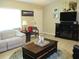 A comfortable living room with a fireplace, ceiling fan, and a plush sofa at 11792 Sw 137Th Loop, Dunnellon, FL 34432