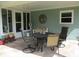 Cozy covered patio with tile flooring, outdoor seating, and a decorative sun and moon wall hanging at 11792 Sw 137Th Loop, Dunnellon, FL 34432