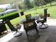 Covered patio with dark metal table and chairs, with nice green lawn at 11792 Sw 137Th Loop, Dunnellon, FL 34432