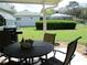 Charming patio with outdoor table and chairs, and beautiful green backyard at 11792 Sw 137Th Loop, Dunnellon, FL 34432