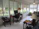 Sunroom featuring tile floors, a ceiling fan, and lots of natural light at 11792 Sw 137Th Loop, Dunnellon, FL 34432