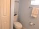 Toilet in a bathroom with white walls, towel rack and window at 11792 Sw 137Th Loop, Dunnellon, FL 34432