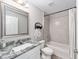 Bright bathroom featuring a tiled shower, granite countertop, and white cabinets at 13105 Sw 77Th Ct, Ocala, FL 34473