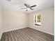 A well-lit bedroom offers hardwood floors, ceiling fan and a window with a view of outdoors at 13180 Sw 80Th St, Dunnellon, FL 34432