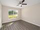 A bright bedroom offers hardwood floors, ceiling fan and a window looking out on greenery at 13180 Sw 80Th St, Dunnellon, FL 34432