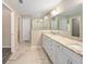 Main bathroom with double sink vanity, tiled floor, large mirror, and glass shower at 13180 Sw 80Th St, Dunnellon, FL 34432