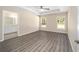 Main bedroom features tray ceiling, two large windows, and wood-look flooring, next to bathroom at 13180 Sw 80Th St, Dunnellon, FL 34432