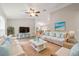 Bright living room features stylish furniture, modern ceiling fan, and decor with beach-inspired colors at 14451 Sw 76Th Avenue Rd, Ocala, FL 34473