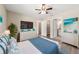 Spacious main bedroom with a ceiling fan, a TV, two dressers, and two entrances to the bathroom at 14451 Sw 76Th Avenue Rd, Ocala, FL 34473