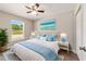 Cozy bedroom featuring a ceiling fan, laminate floors, and large window with backyard views at 15428 Sw 60Th Cir, Ocala, FL 34473