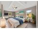Serene main bedroom retreat with tray ceiling, ensuite bathroom, and backyard views at 15428 Sw 60Th Cir, Ocala, FL 34473