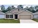 Charming one-story home featuring a two-car garage, neutral stucco exterior, and well-manicured lawn at 2889 Ne 21St Terrace Rd, Ocala, FL 34470