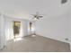 Bright bedroom with neutral carpet, ceiling fan, and sliding glass door to a patio, offering comfort and natural light at 3616 Ne 17Th Ln, Ocala, FL 34470